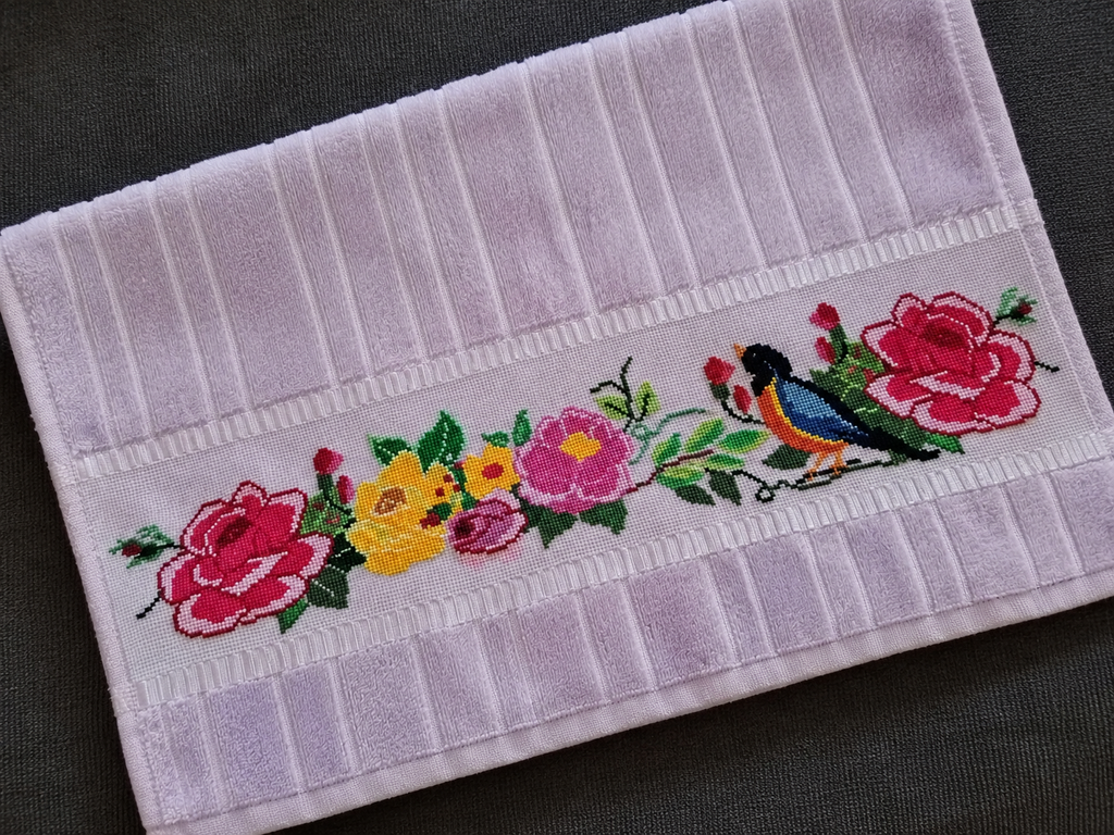 Toalha lilás com flores coloridas e pássaro bordados à mão em ponto cruz por Josilaine.